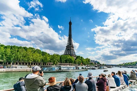 Seine River cruise boat passing the Eiffel Tower in Paris